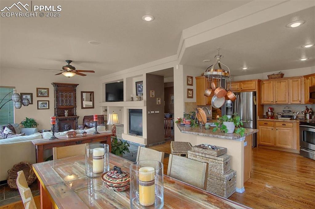 Image 10 of 42: Dining space with recessed lighting, ceiling fan, a glass covered fireplace