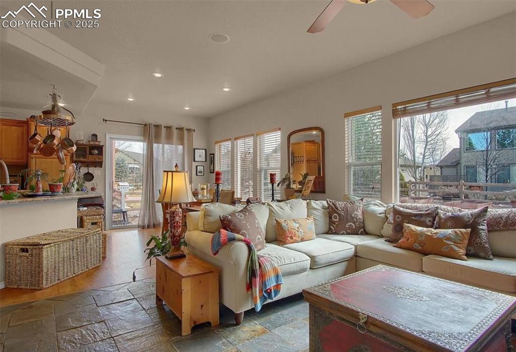 Image 12 of 42: Living area featuring ceiling fan, recessed lighting, and stone tile floors