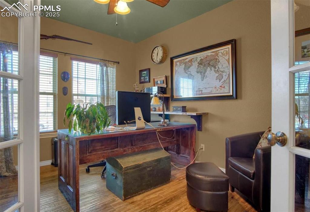 Image 15 of 42: Office with a ceiling fan, baseboards, and wood finished floors