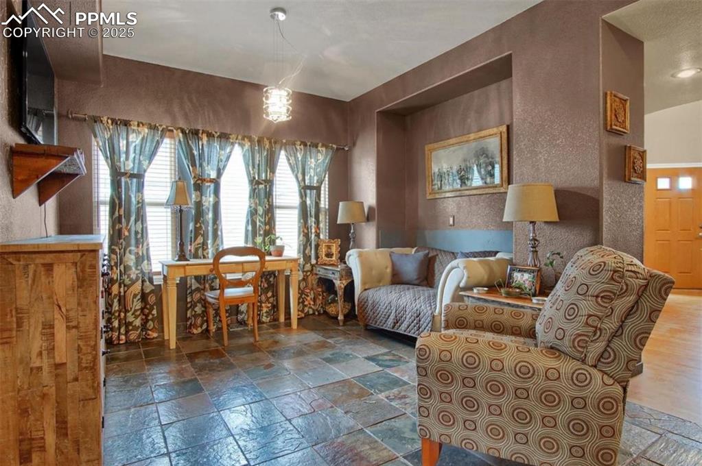 Image 17 of 42: Sitting room with a textured wall and stone tile flooring
