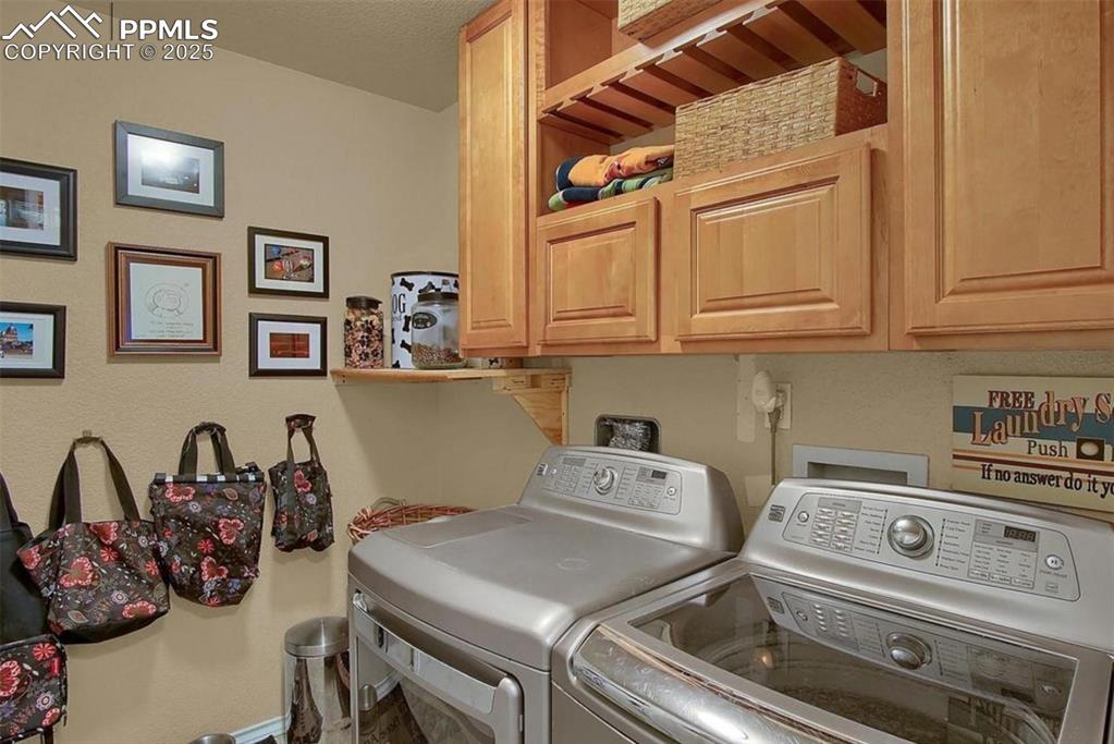 Image 22 of 42: Laundry room featuring independent washer and dryer and cabinet space