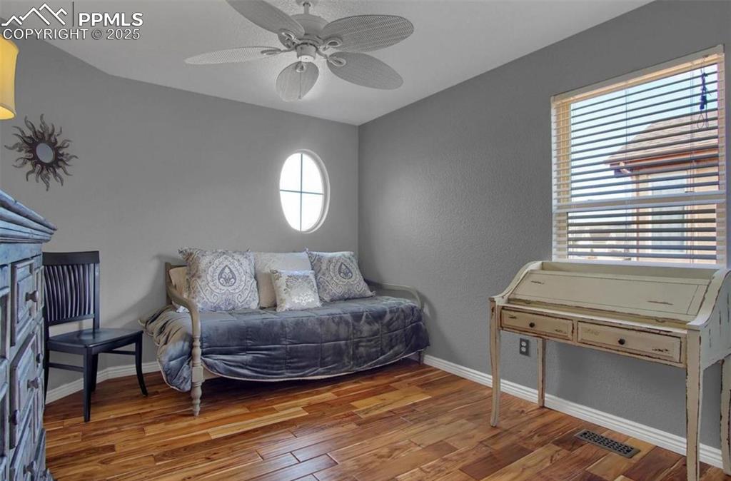 Image 27 of 42: Bedroom with visible vents, a textured wall, wood finished floors, baseboar