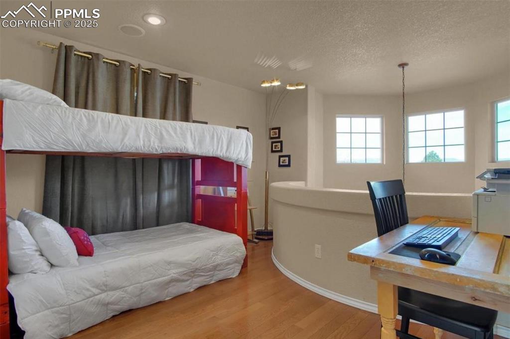Image 28 of 42: Bedroom featuring a textured ceiling, baseboards, recessed lighting, and wo