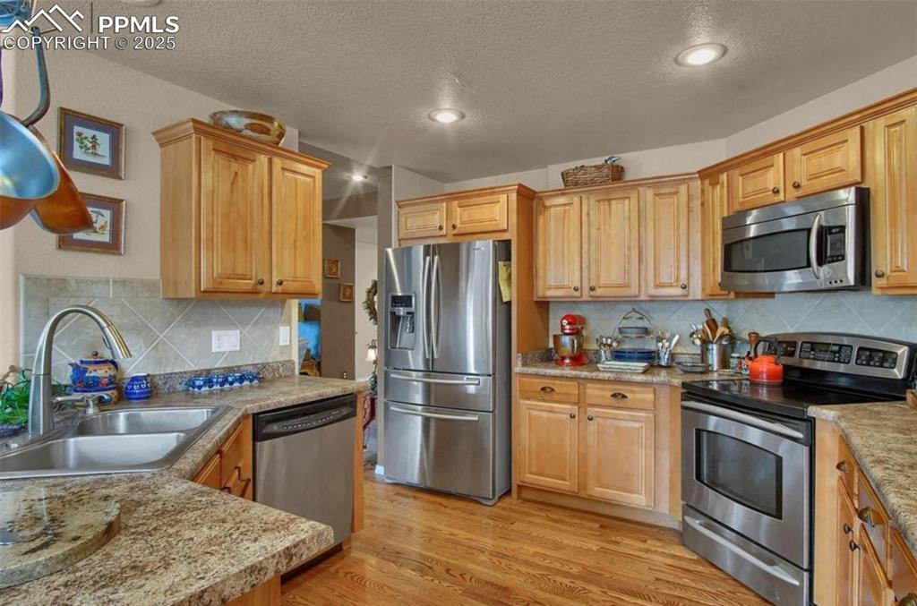 Image 4 of 42: Kitchen featuring a sink, appliances with stainless steel finishes, light w