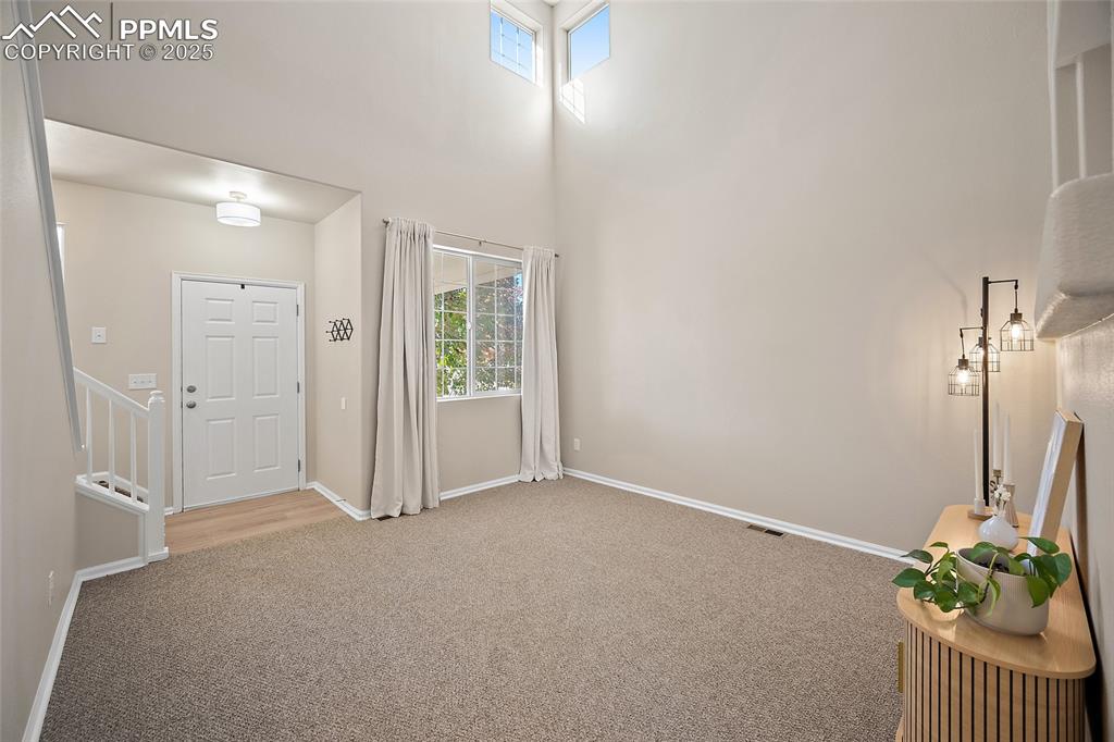 Image 4 of 45: Entry living space with souring vaulted ceilings