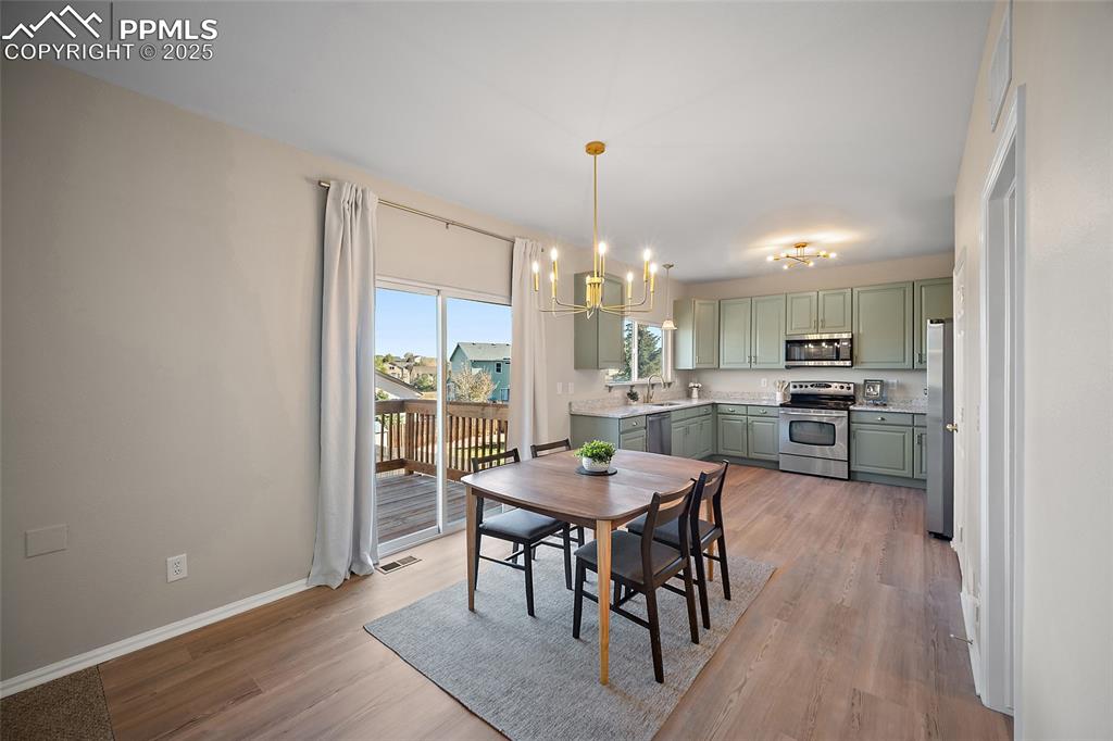 Image 8 of 45: Beautifully lit dining area with new brushed gold fixtures