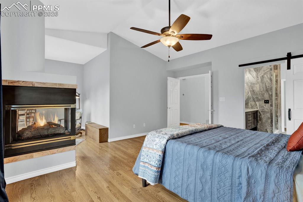 Image 17 of 49: Spacious bedroom with barn door into bathroom