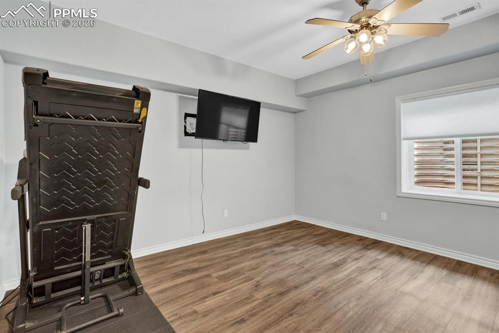 Image 37 of 49: Basement Bedroom 5 was used as a workout space - TV and Treadmill stay