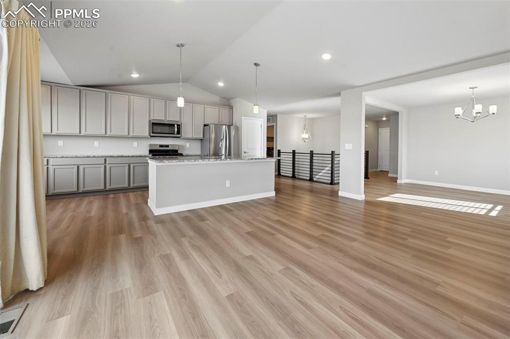 Image 10 of 42: Open concept living, looking towards front door and stairs 