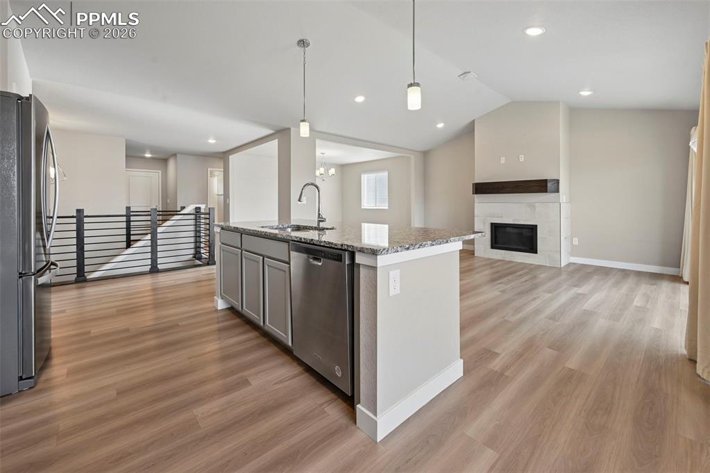 Image 12 of 42: Designer kitchen overlooking living room with fireplace 