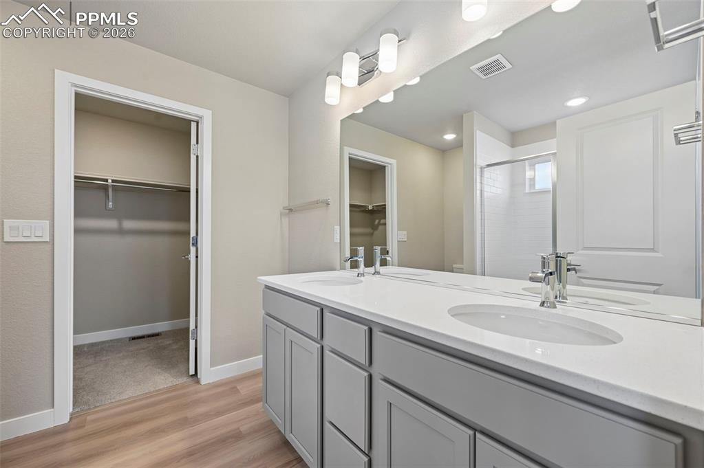 Image 19 of 42: Primary bathroom with double vanity, shower and large walk in closet 
