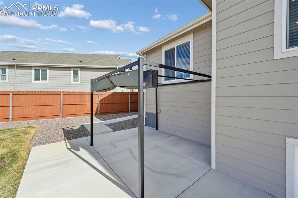 Image 37 of 42: Extended concrete patio with pergola 