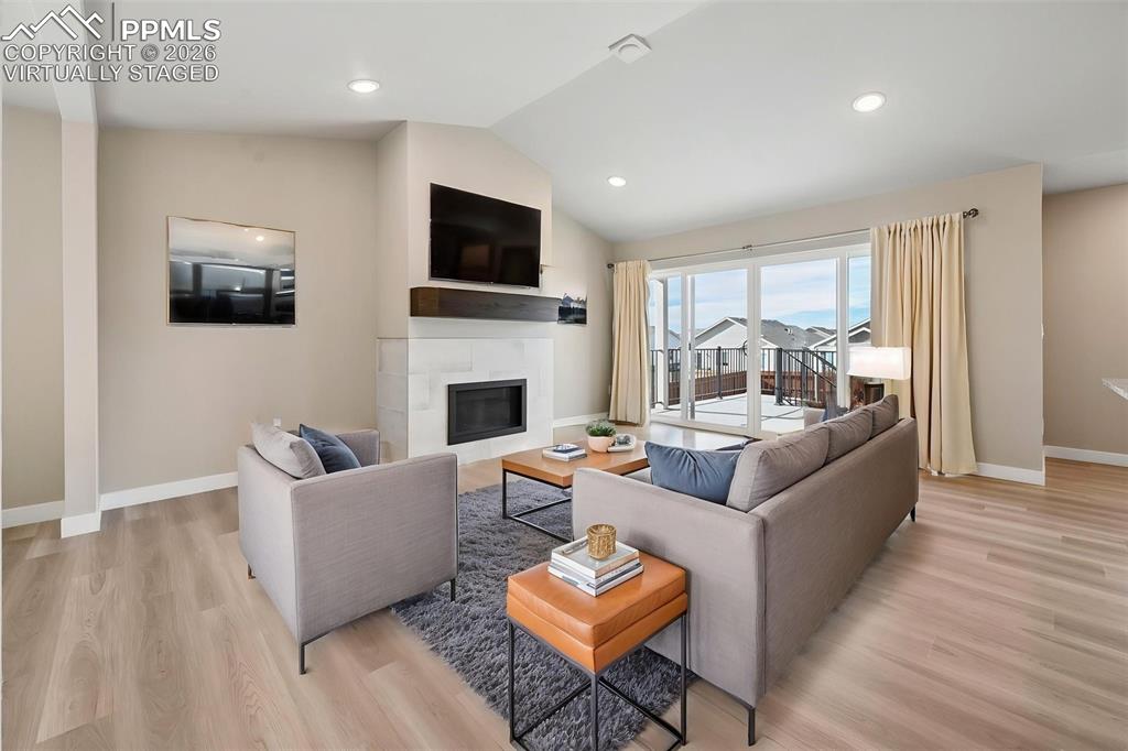 Image 7 of 42: Virtually staged living room with fireplace and walk-out! 