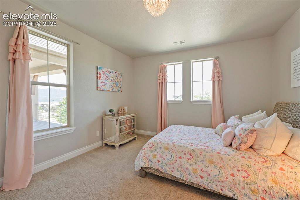 Image 24 of 38: Upstairs bedroom with an amazing Pikes Peak view