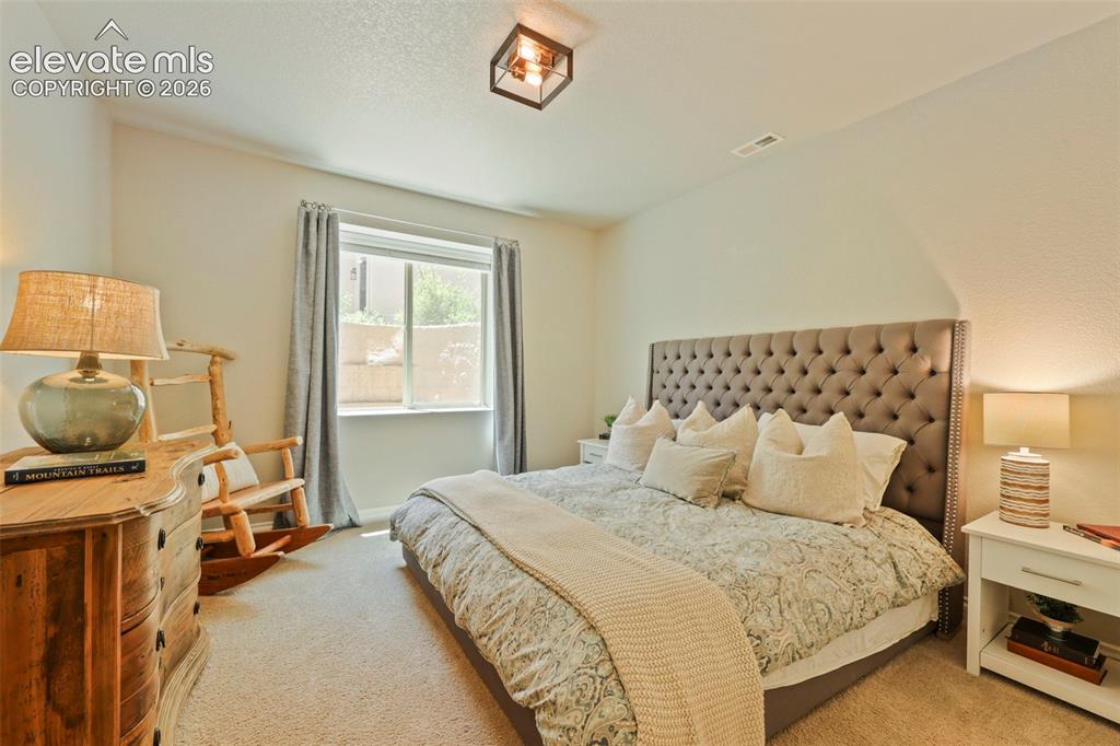 Image 31 of 38: Bedroom on lower level with adjacent bath