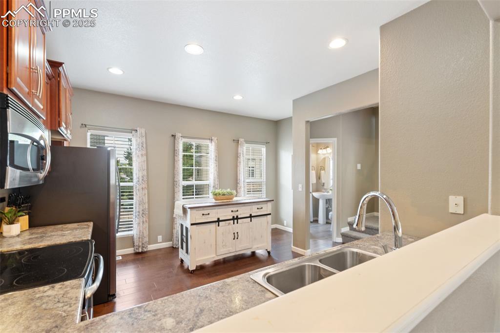 Image 11 of 35: Kitchen featuring dark wood-style flooring, appliances with stainless steel