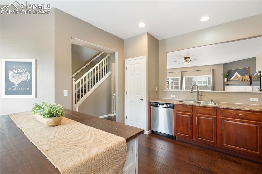 Image 15 of 35: Kitchen with dark wood-style floors, stainless steel dishwasher, brown cabi