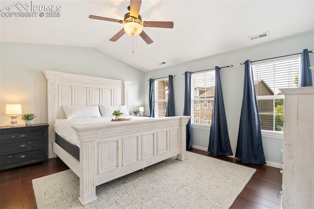 Image 17 of 35: Bedroom with vaulted ceiling, dark wood-style floors, and a ceiling fan