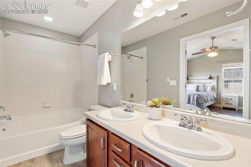 Image 20 of 35: Bathroom with ensuite bathroom, shower / bath combination, wood finished fl