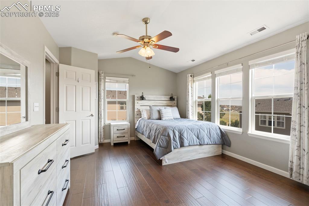 Image 23 of 35: Bedroom with lofted ceiling, dark wood-style floors, and ceiling fan