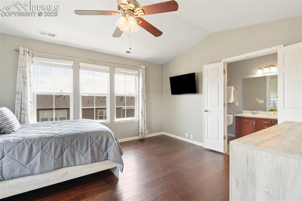 Image 24 of 35: Bedroom featuring vaulted ceiling, dark wood finished floors, ceiling fan, 
