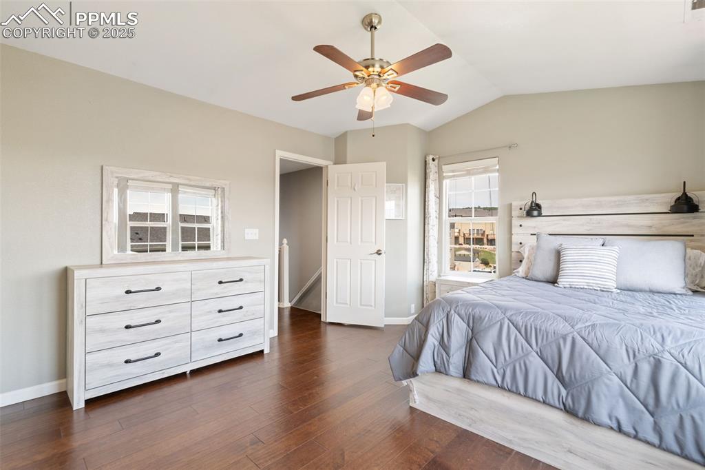 Image 25 of 35: Bedroom with dark wood finished floors, lofted ceiling, and a ceiling fan