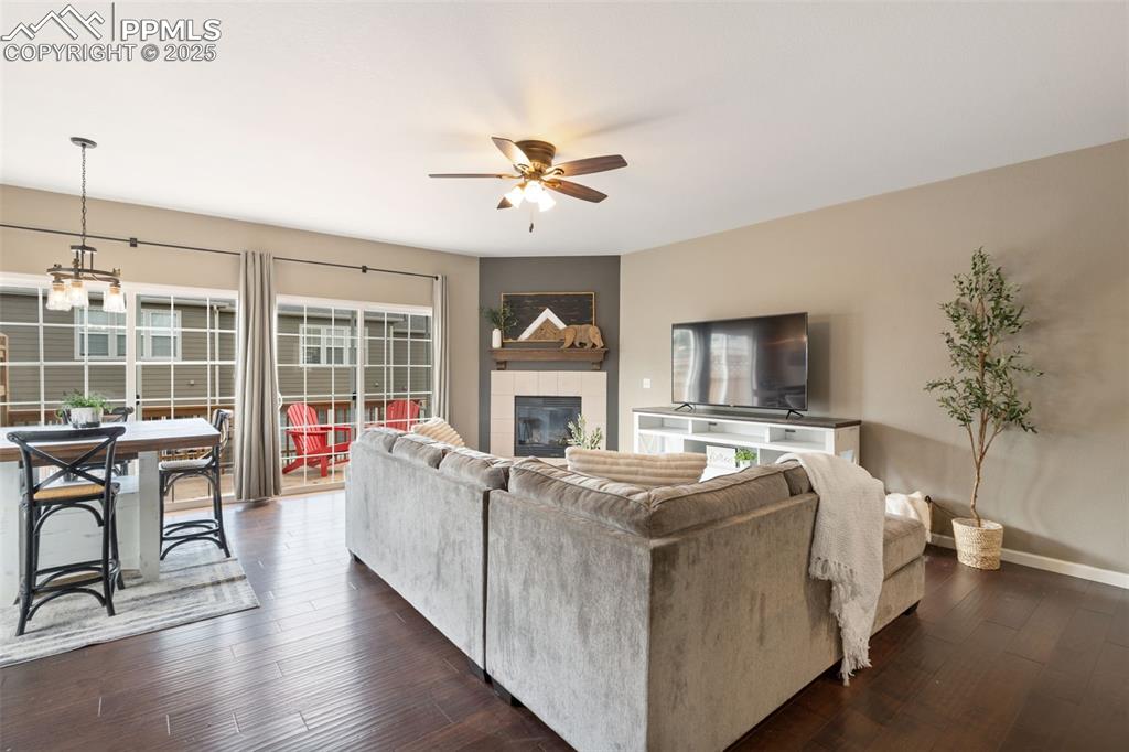 Image 3 of 35: Living area featuring ceiling fan, dark wood finished floors, and a tiled f