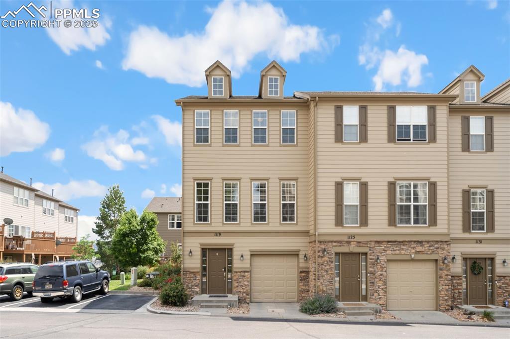 Image 35 of 35: View of front of home with stone siding and an attached garage