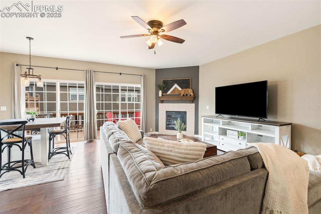 Image 4 of 35: Living room with hardwood / wood-style floors, ceiling fan, and a tile fire