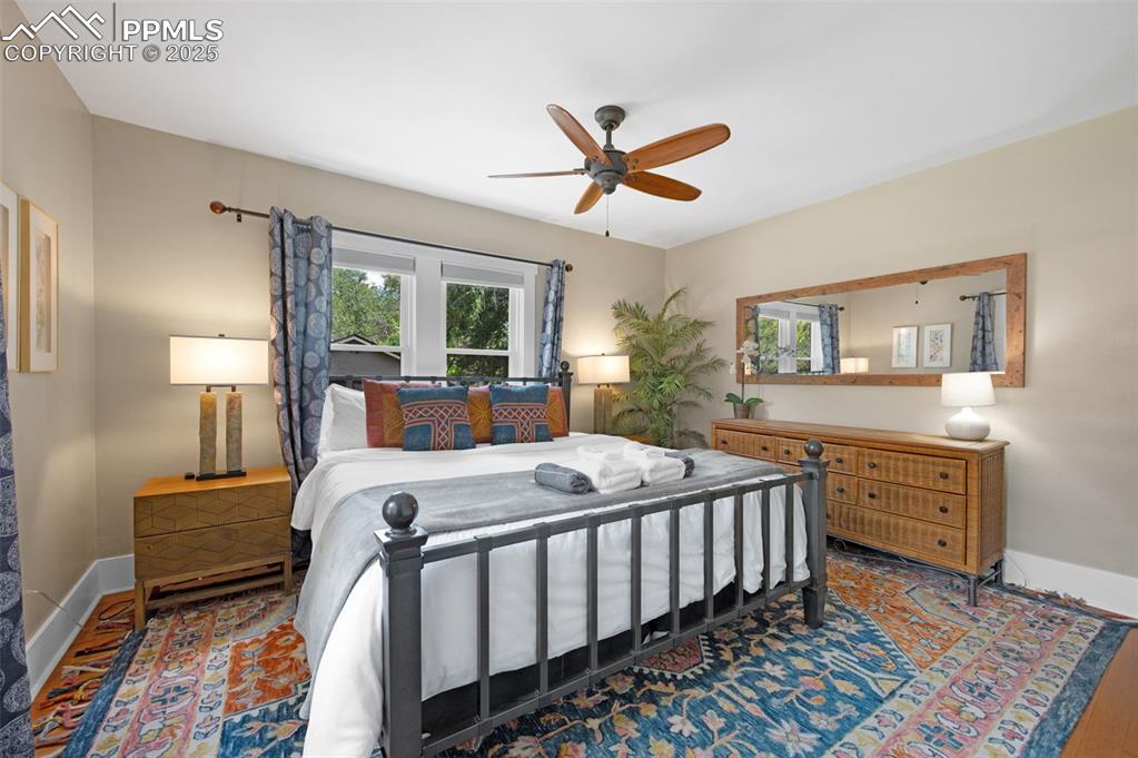Image 13 of 42: Primary bedroom with wood floors and sunshine