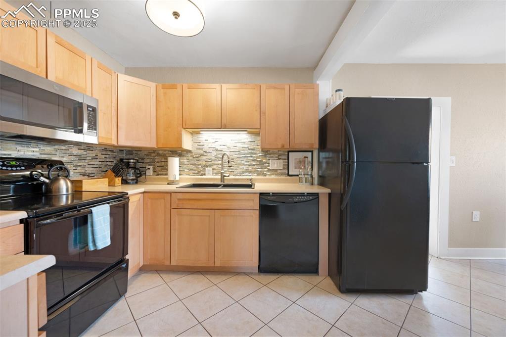 Image 7 of 42: Updated kitchen with glass tile back splash and tile floors