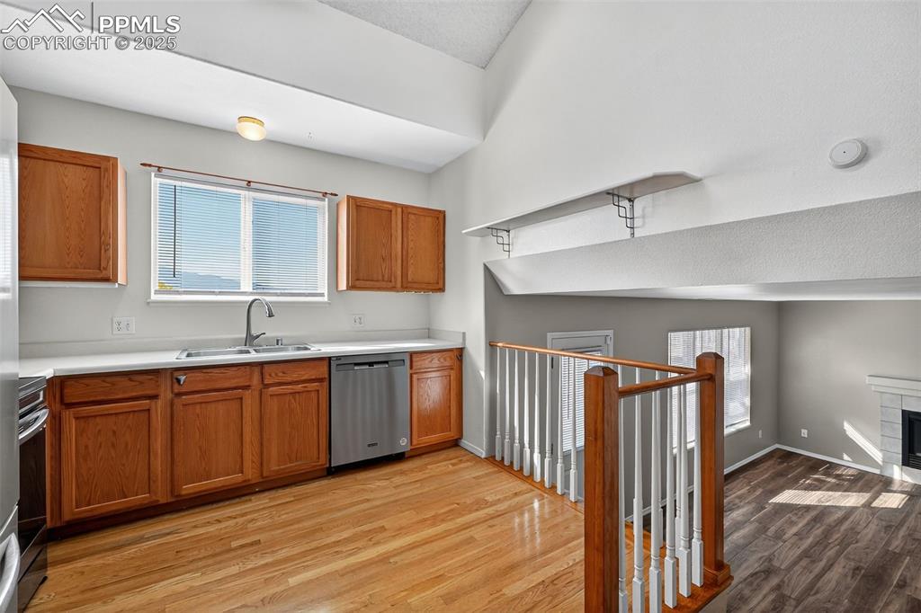 Image 10 of 29: Kitchen featuring light countertops, brown cabinetry, light wood-style floo