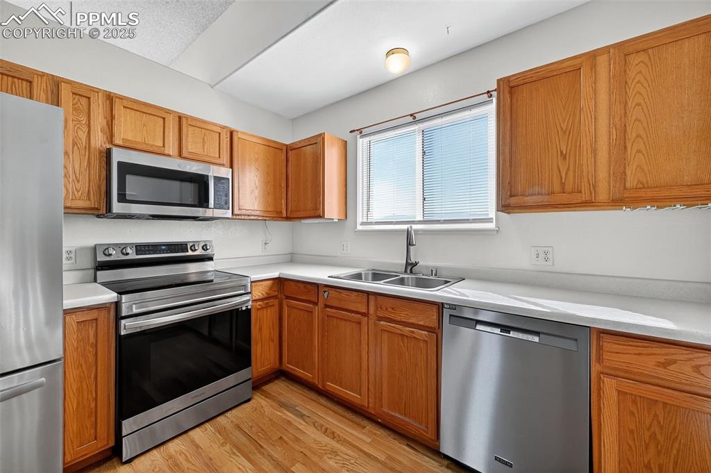 Image 11 of 29: Kitchen featuring stainless steel appliances, light countertops, light wood