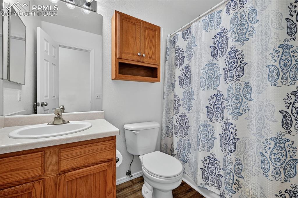Image 22 of 29: Bathroom featuring a shower with curtain, vanity, and dark wood finished fl