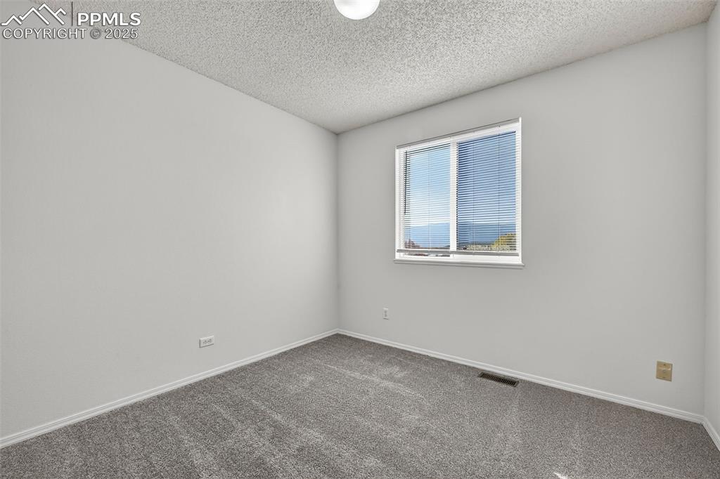 Image 23 of 29: Spare room featuring carpet floors and a textured ceiling