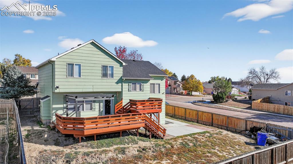 Image 4 of 29: Rear view of house with a fenced backyard and a residential view