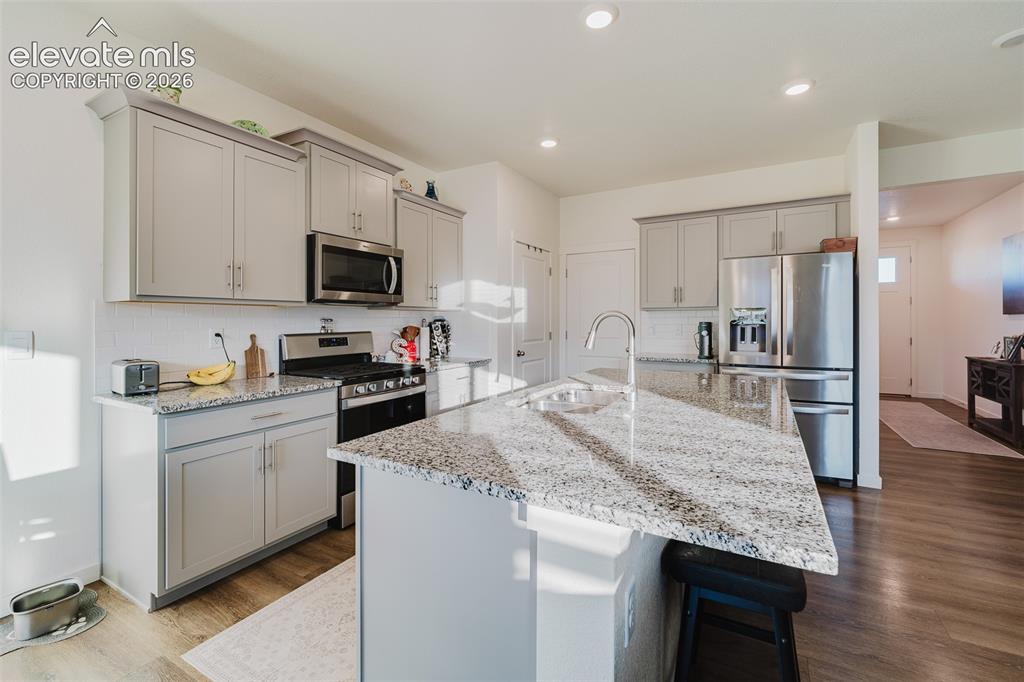 Image 13 of 47: The Island Kitchen boasts granite countertops, wood cabinets, recessed ligh