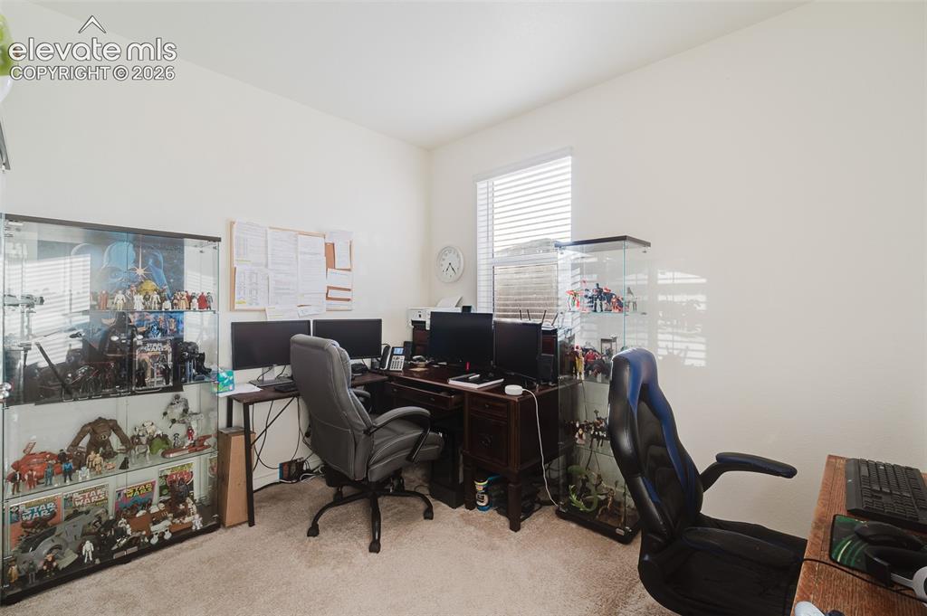 Image 17 of 47: Main Level Bedroom (currently an office) with neutral carpet.