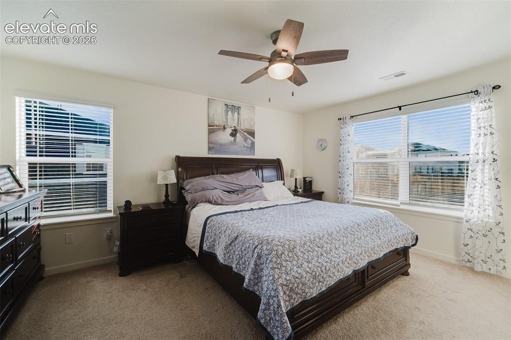 Image 24 of 47: The Primary Bedroom is a private retreat featuring neutral carpet, a lighte