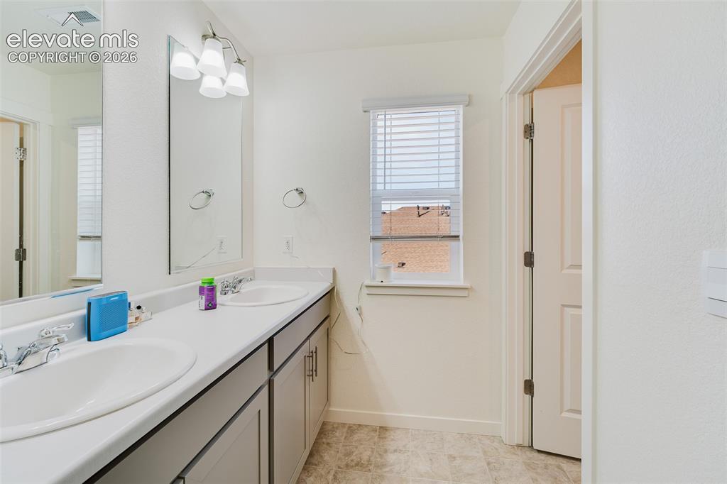 Image 32 of 47: Upper Level Full Bathroom with dual sink vanity, mirrors, and tub/shower.