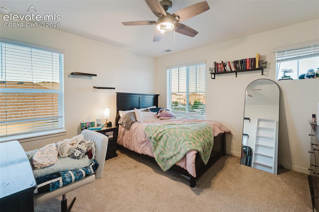 Image 36 of 47: Upper Level Bedroom #5 with lighted ceiling fan and neutral carpet.