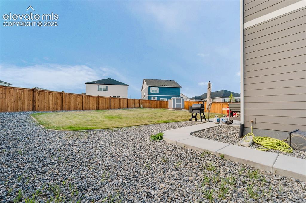 Image 40 of 47: View of backyard and storage shed for tools and toys.