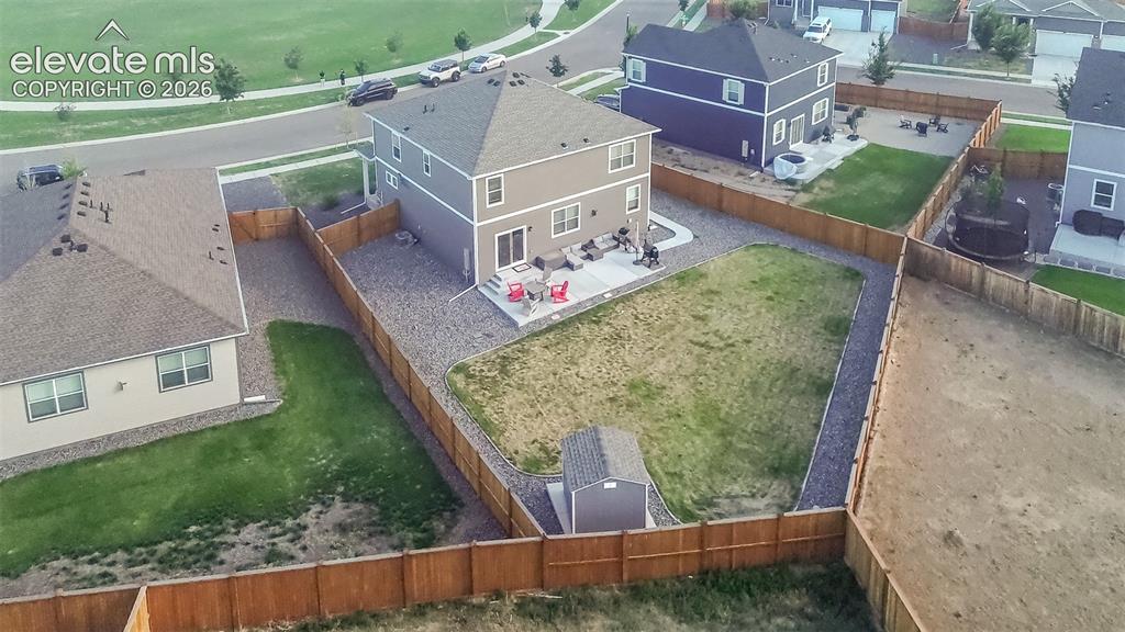 Image 42 of 47: Aerial rear view of home and fenced backyard.
