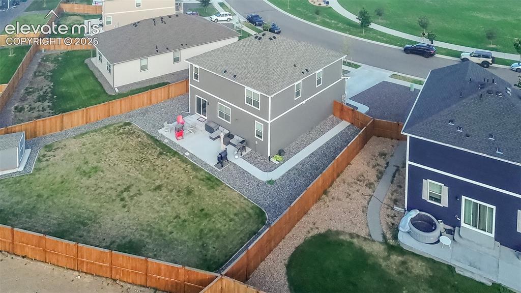 Image 43 of 47: Aerial view of home and fenced backyard with storage shed, patio, and side