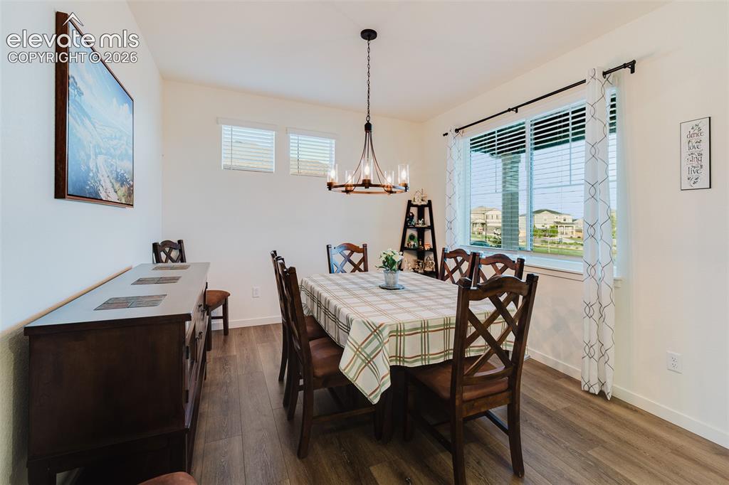 Image 6 of 47: Formal Dining Room with modern light fixture and front yard views.