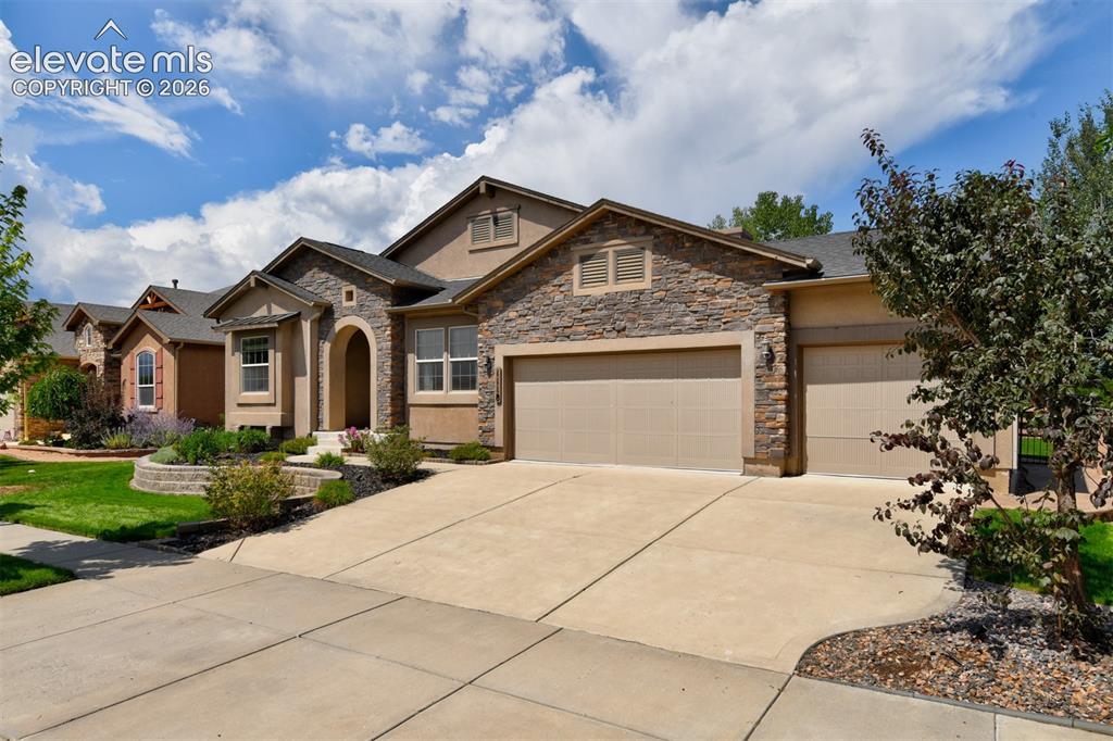 Image 1 of 49: Stucco and stone exterior with an arched entryway