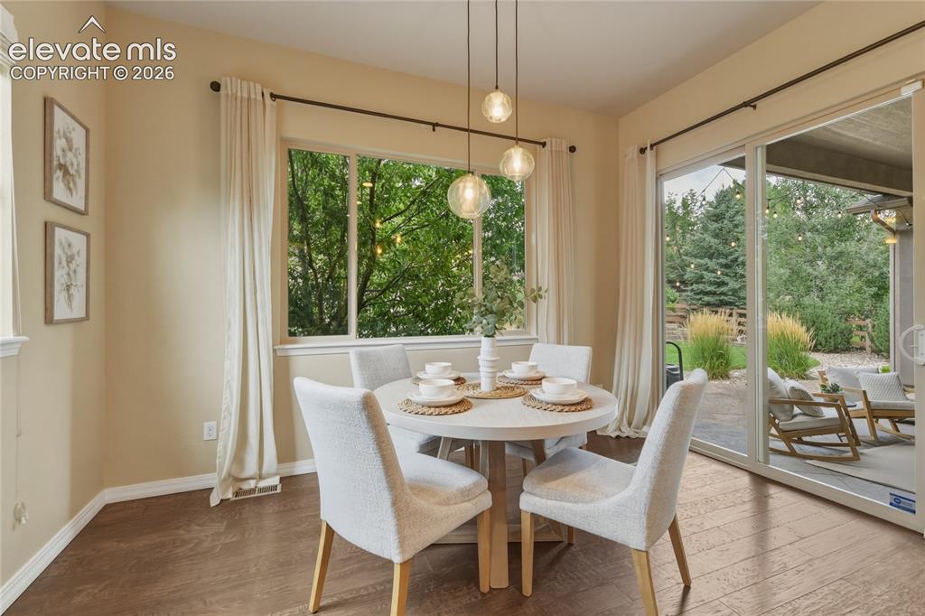 Image 12 of 49: Wood-finish flooring, large window with natural light, modern pendant light