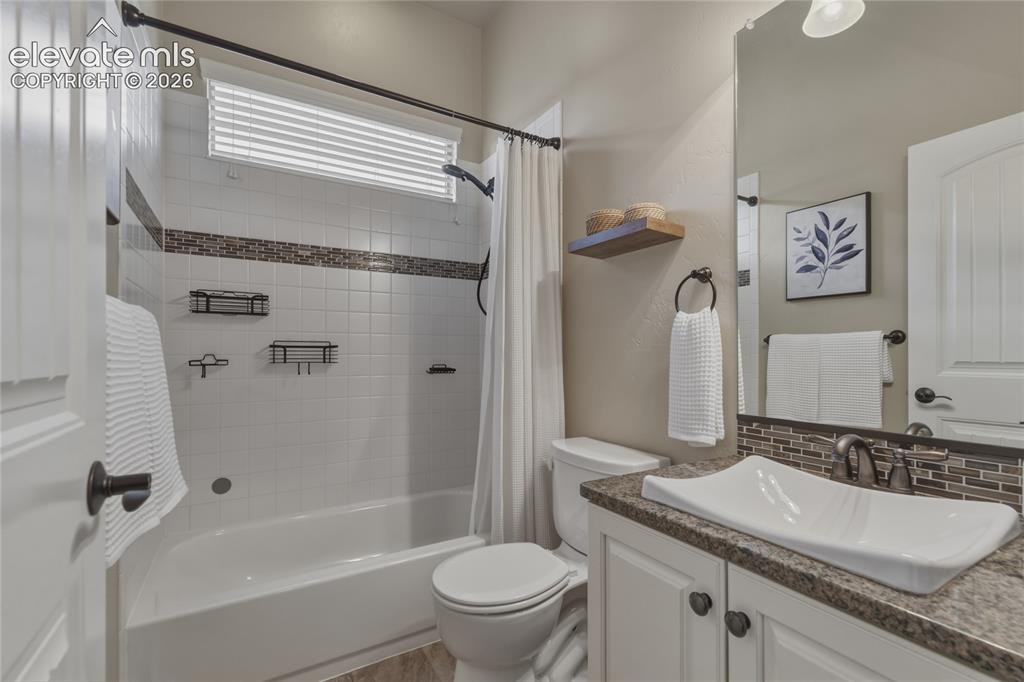 Image 16 of 49: White subway tile bath surround with mosaic accent, vessel sink, granite co