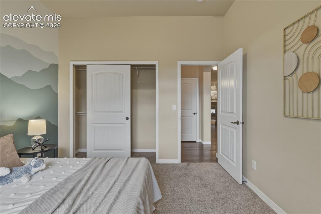 Image 25 of 49: Bright primary bedroom with dual closets featuring white six-panel doors an