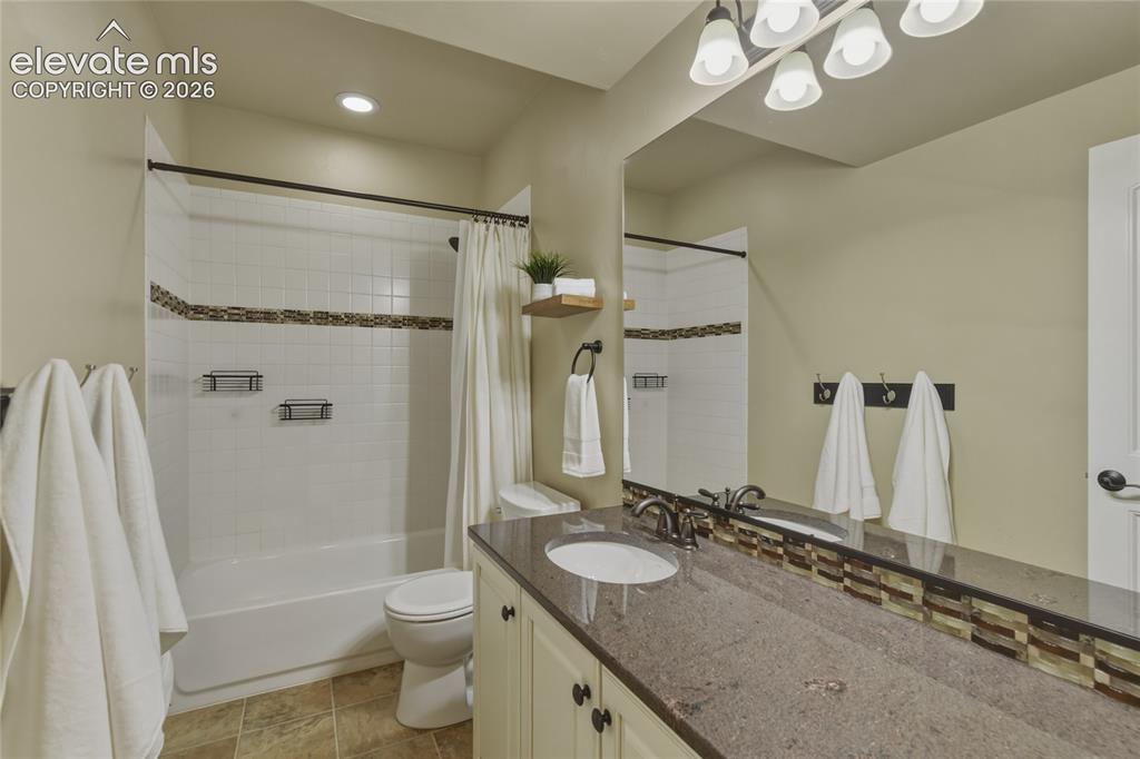 Image 32 of 49: Bathroom featuring a tiled shower/tub combination, single vanity with a sol